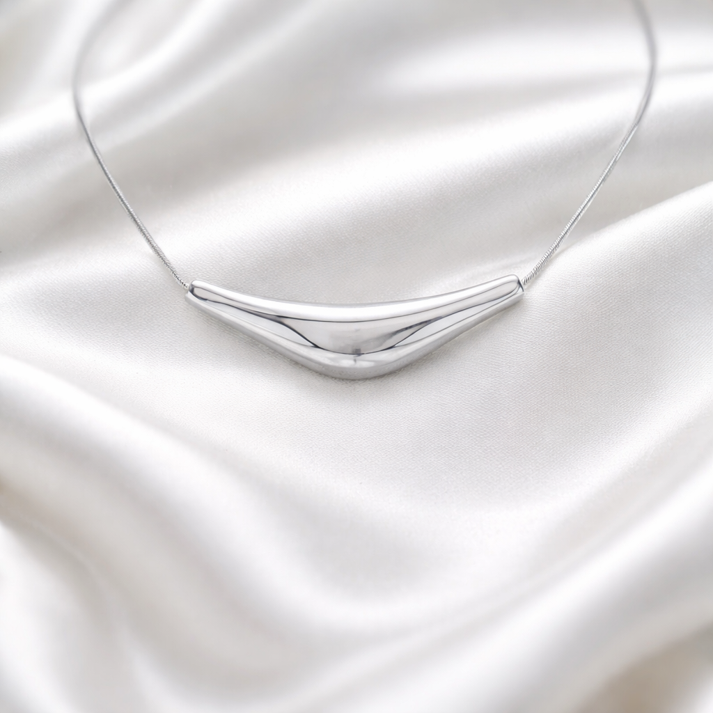 Solace Curve Necklace silver necklace on a white satin background